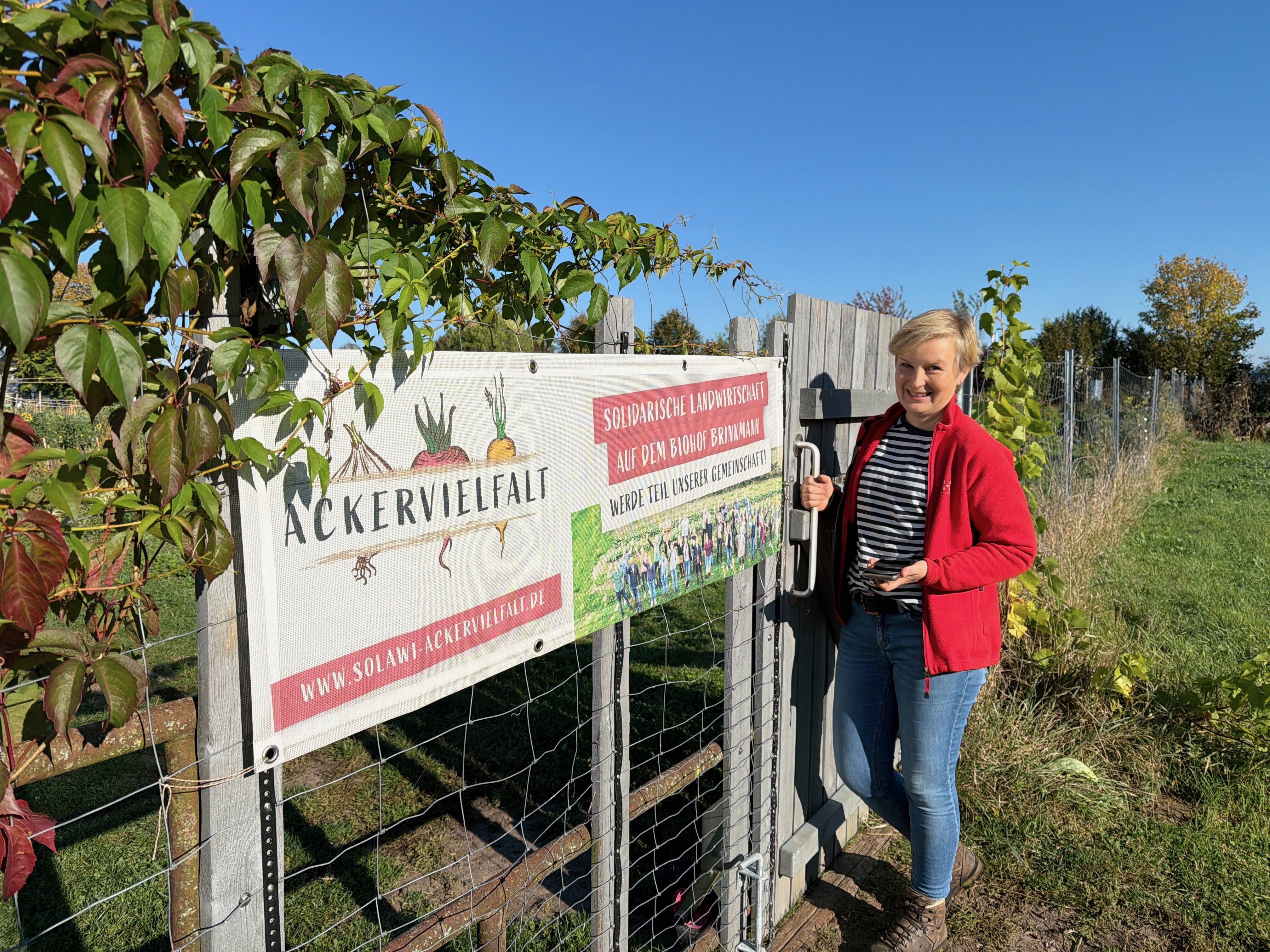 Wiebke Brinkmann-Roitsch vor dem Ackergelände der Solidarischen Landwirtschaft Ackervielfalt eG